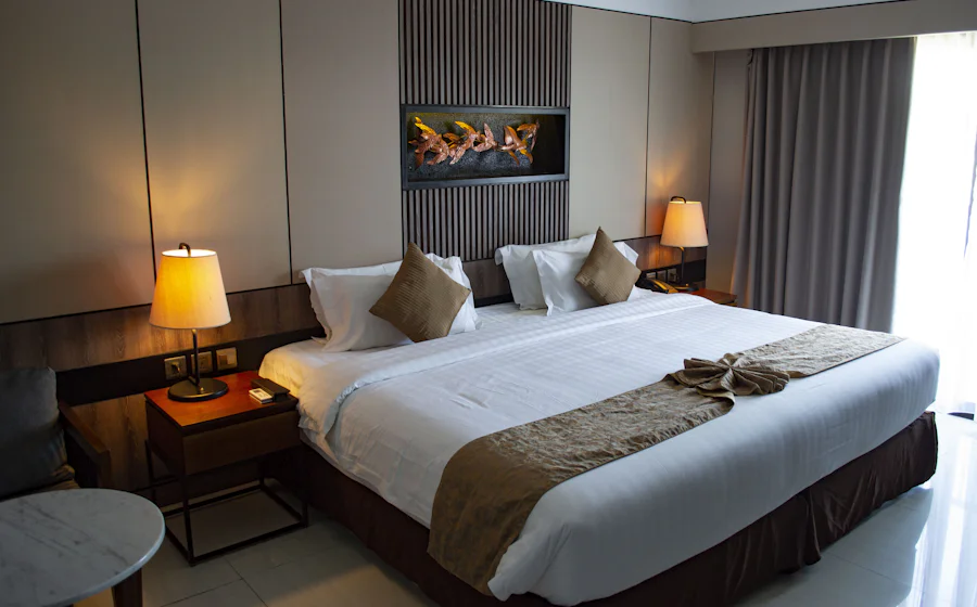 A tidy hotel room with a made bed and bedside lamps
